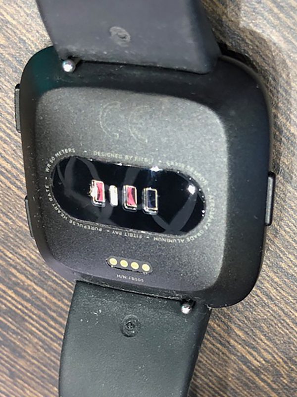 Rückseite der fitbit Versa(TM) Smartwatch mit Ladekontakten